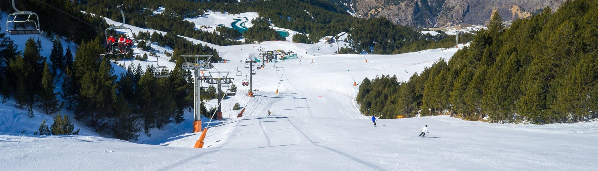 Skiërs op de pistes van Andorra naast een skilift.