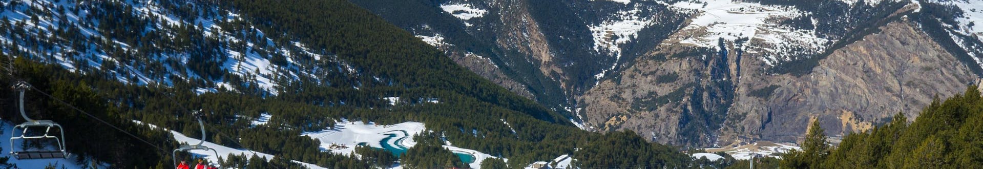 Skiers on the slopes of Andorra next to a ski lift.