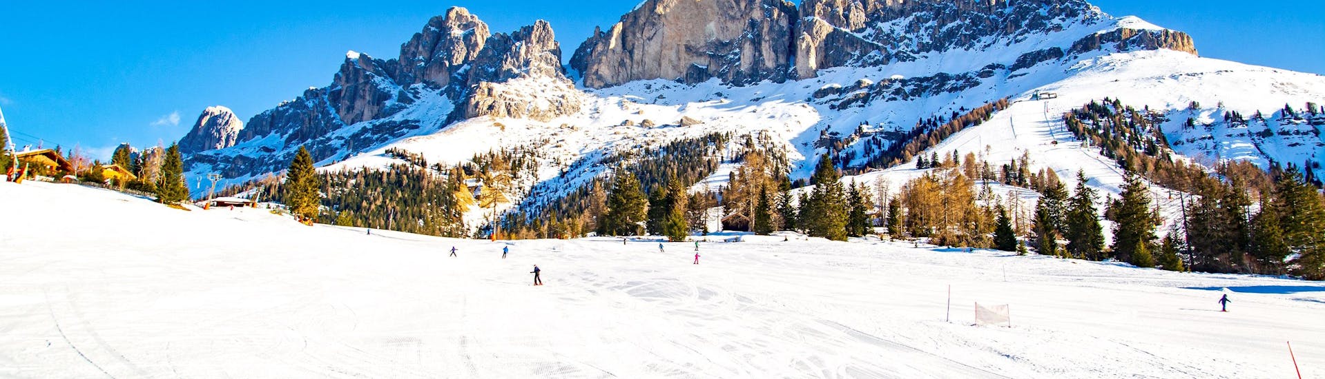 Skiers on the slopes of Carezzo al Lago on a sunny winter day.
