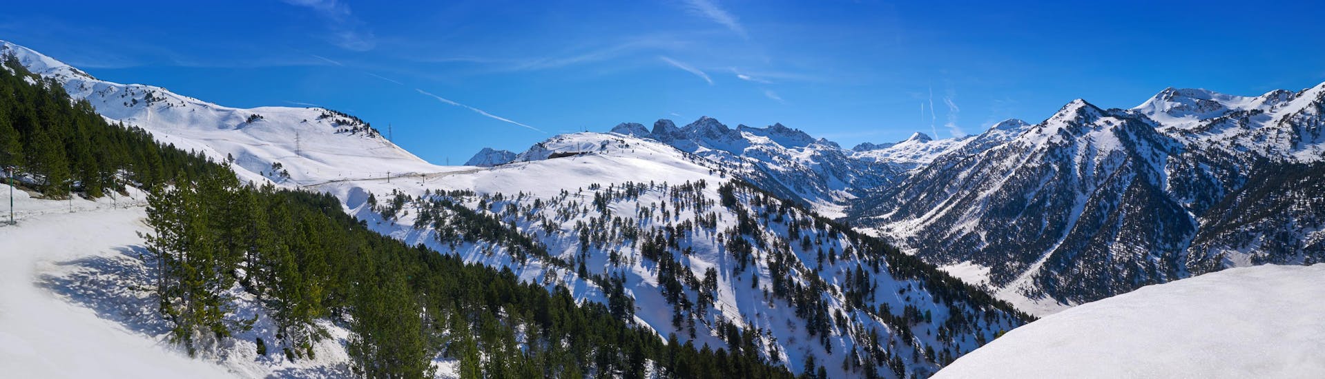 View of the pine-covered mountains in Catalonia where ski schools offer ski lessons. 