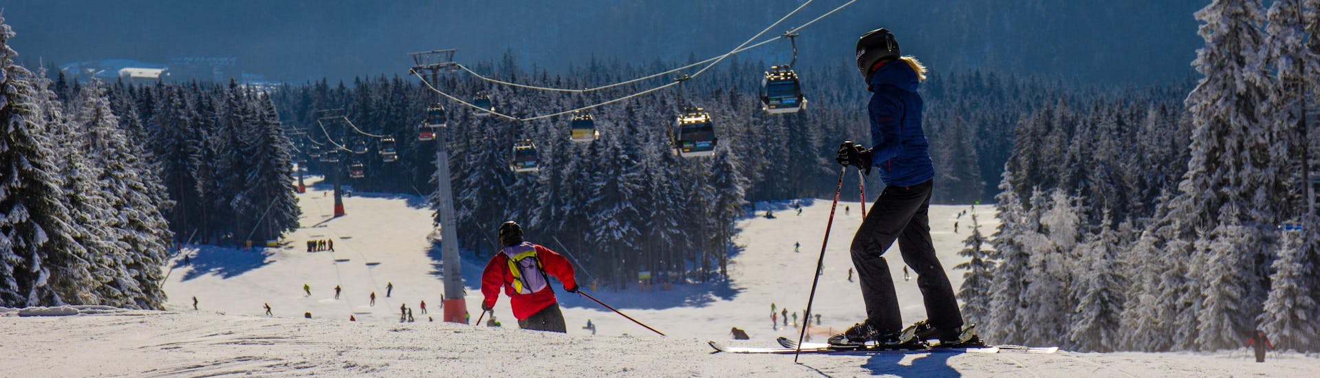 Blick auf die Pisten des Skigebiets Černá Hora, wo die örtlichen Skischulen ihre Skikurse anbieten.