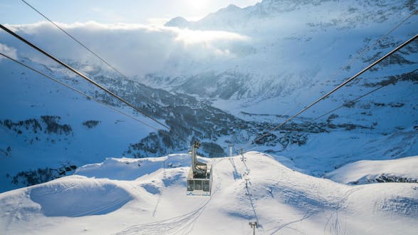 An image of a cable car ascending the mountain in the italian ski resort of Cervinia, where visitors can learn to ski during their ski lessons provided by local ski schools.
