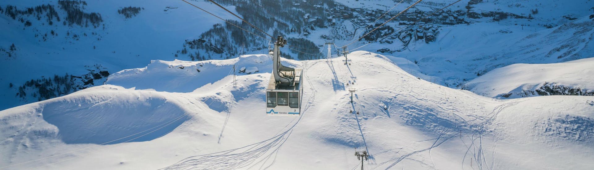 An image of a cable car ascending the mountain in the italian ski resort of Cervinia in the Aosta Valley, where visitors can learn to ski during their ski lessons provided by local ski schools.