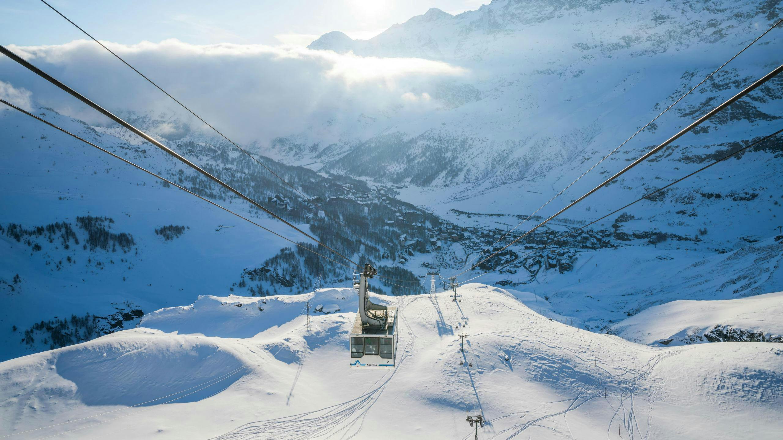 ski-school-cervinia_SEM-Resort-Hero An image of a cable car ascending the mountain in the italian ski resort of Cervinia, where visitors can learn to ski during their ski lessons provided by local ski schools.