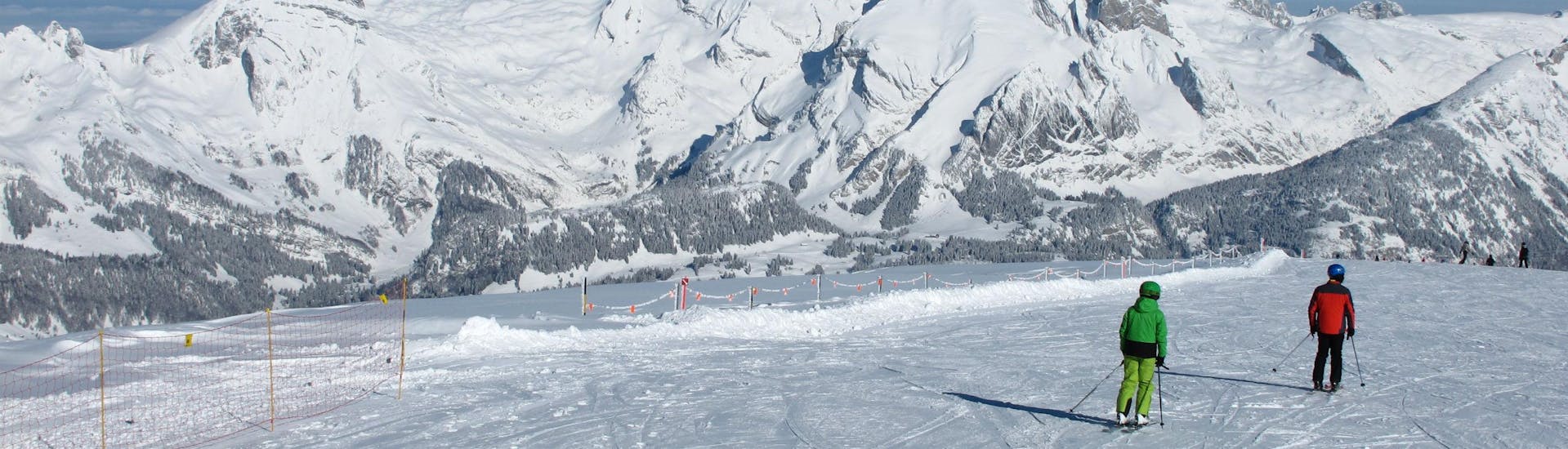 Deux skieurs descendent sous le soleil une des pistes de la station de ski de Chaeserrugg, où les visiteurs peuvent réserver des cours de ski avec les écoles de ski locales.