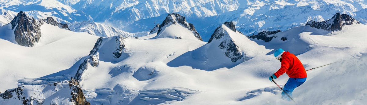 ski-school-chamonix-les-planards_SEM-Resort-Hero A skier is skiing through fresh powder snow on one of the slopes in Chamonix - Les Planards, where local ski schools offer a variety of ski lessons.
