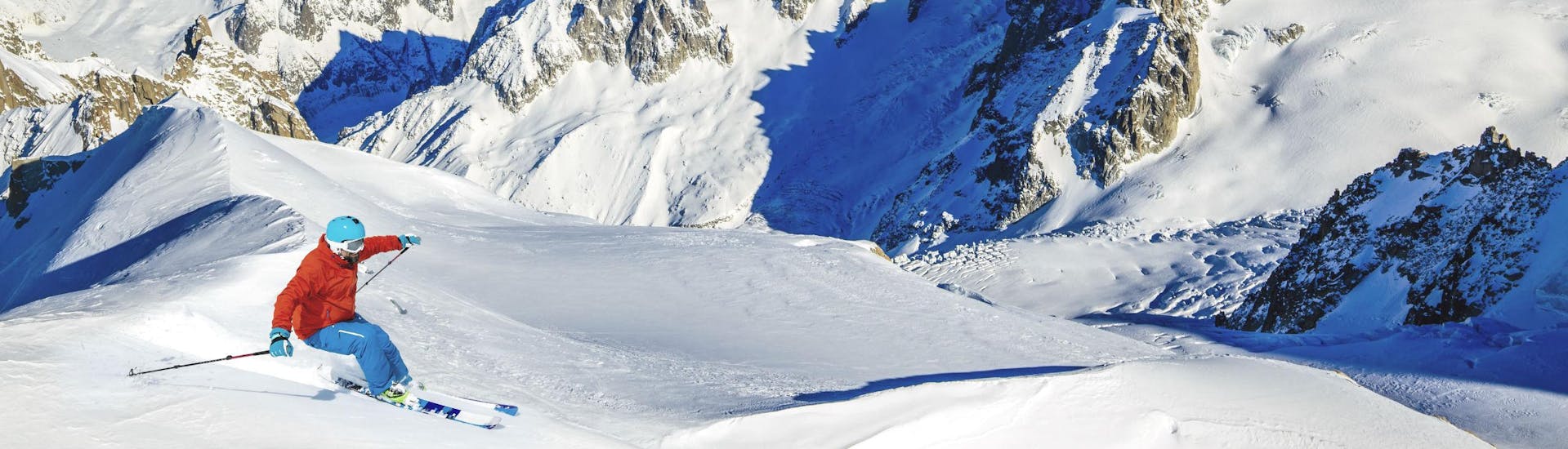 A skier is skiing through fresh powder snow on one of the slopes in Chamonix - Mont Blanc in Haute-Savoie, where local ski schools offer a variety of ski lessons.