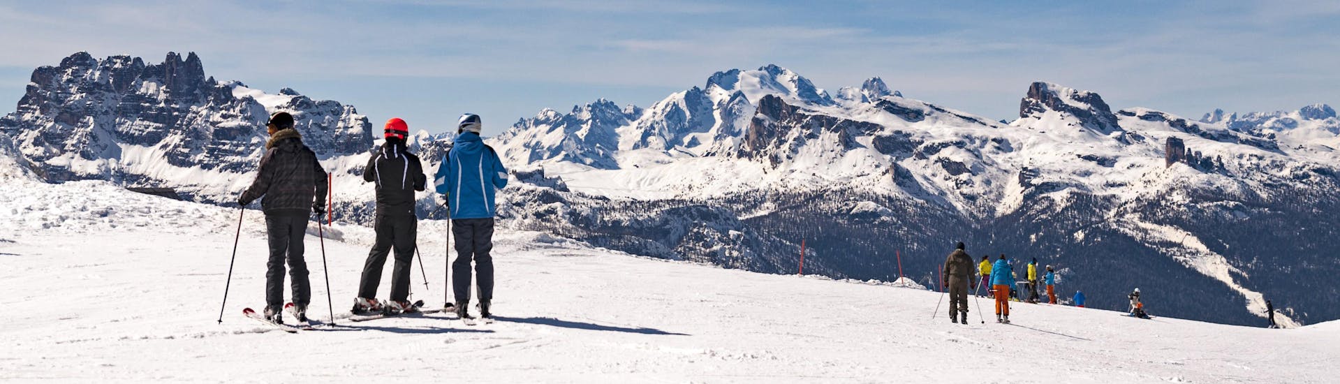 Skifahrer mit Panoramablick auf die Dolomiten, nehmen an Skikurse von Skischulen im Skigebiet Cortina d'Ampezzo teil.