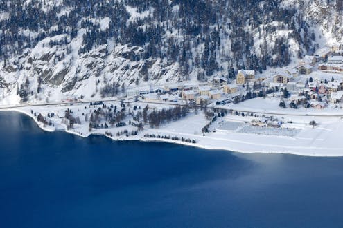 Un pueblo cubierto de nieve junto al lago en Corvatsch-Silvaplana, en Suiza.