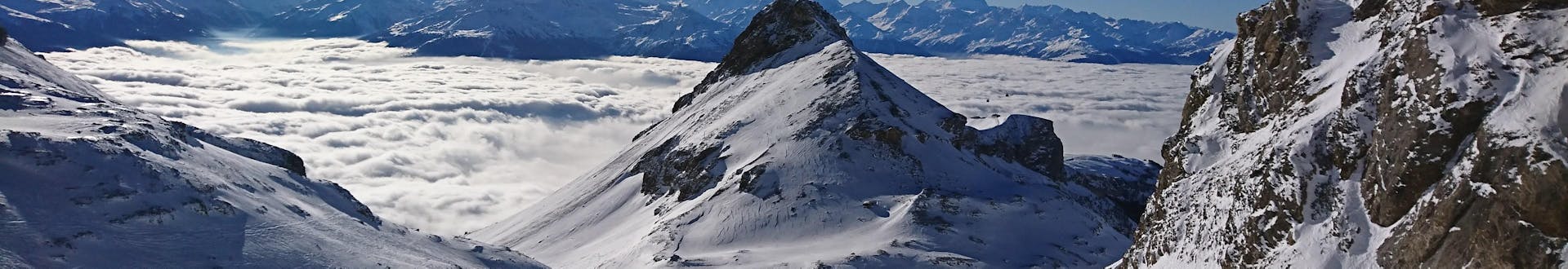 Blick auf die alpine Landschaft und die Pisten von Crans-Montana, wo die örtlichen Skischulen ihre Skikurse anbieten.