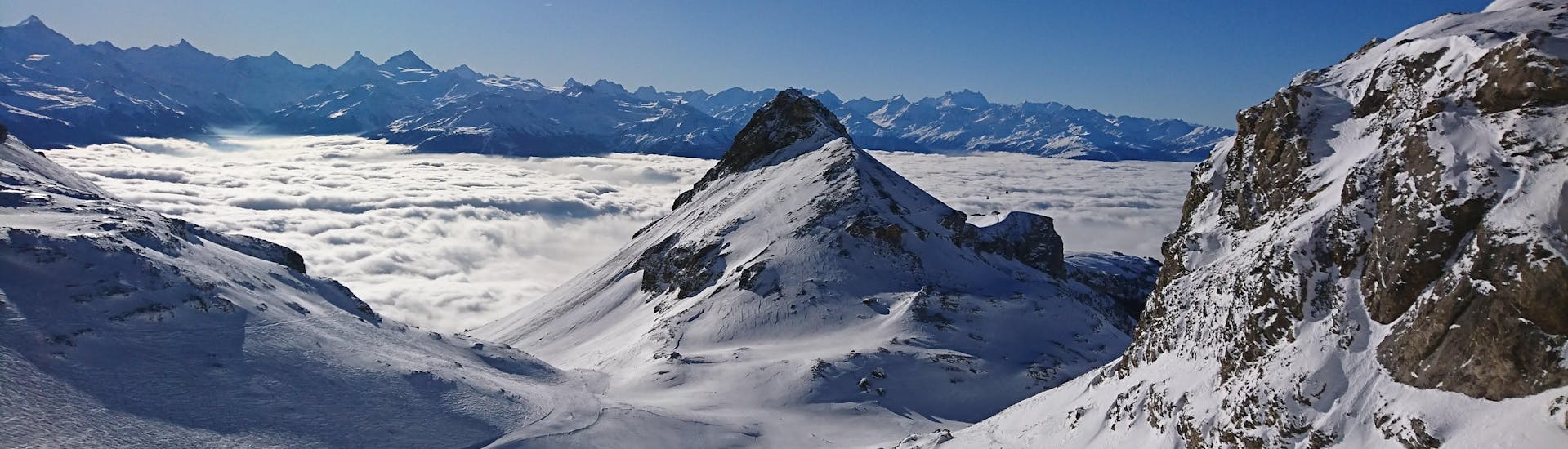 Blick auf die alpine Landschaft und die Pisten von Crans-Montana, wo die örtlichen Skischulen ihre Skikurse anbieten.