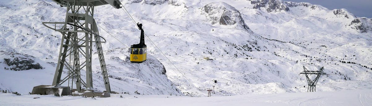 ski-school-dachstein-krippenstein_SEM-Resort-Hero Blick auf die Gondel im verschneiten Skigebiet Dachstein Krippenstein, wo örtliche Skischulen ihre Skikurse anbieten.