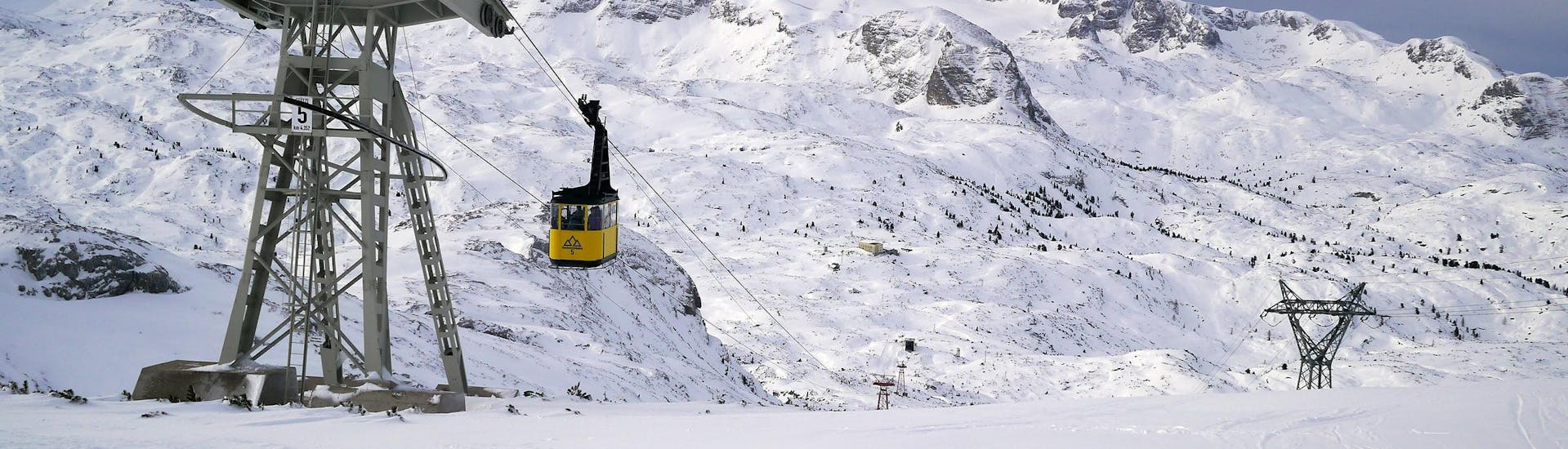 Blick auf die Gondel im verschneiten Skigebiet Dachstein Krippenstein, wo örtliche Skischulen ihre Skikurse anbieten.