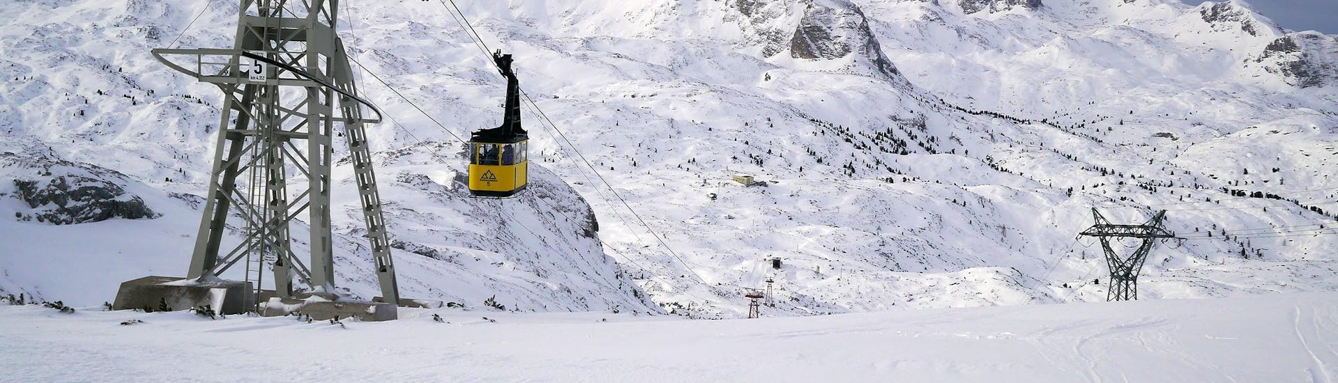 Blick auf die Gondel im verschneiten Skigebiet Dachstein Krippenstein, wo örtliche Skischulen ihre Skikurse anbieten.