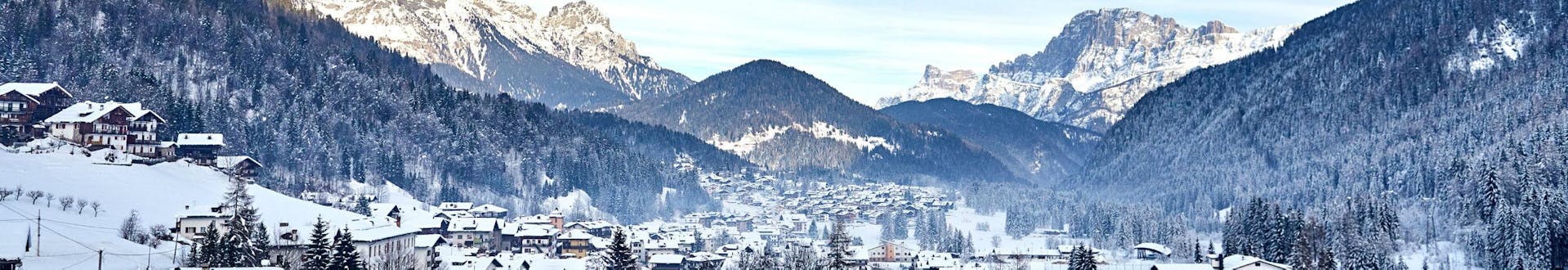 An image of Falcade, a picturesque Italian village nestled between the mountains, where aspiring skiers can book ski lessons with one of the local ski schools.