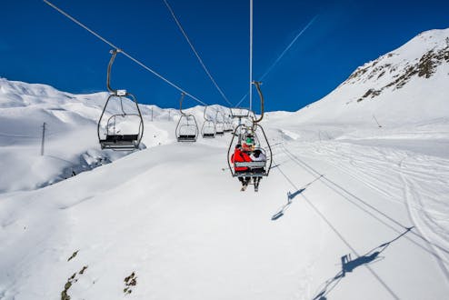 Eine Gruppe Skifahrer fährt im spanischen Skigebiet Formigal mit dem Skilift den Berg hoch, wo sie mit ihrem von einer örtlichen Skischule organisierten Skikurs beginnen.