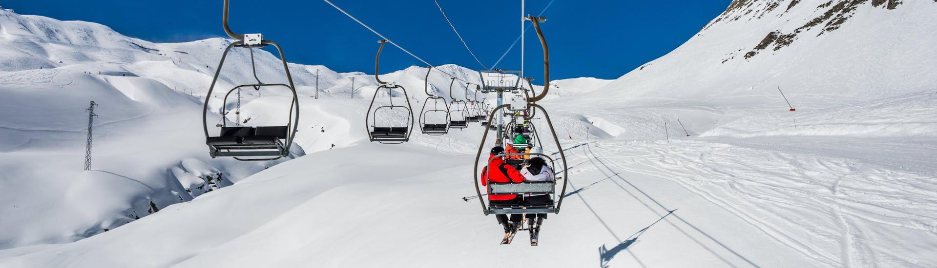 Photo d'une remontée mécanique transportant des skieurs au sommet d'une piste de ski dans la station de ski espagnole de Formigal, où les visiteurs qui veulent apprendre à skier peuvent réserver des cours de ski auprès des écoles de ski locales.