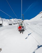 An image of a ski lift carrying skiers to the top of the ski slope in the Spanish ski resort of Formigal, where visitors who want to learn to ski can book ski lessons with local ski schools.