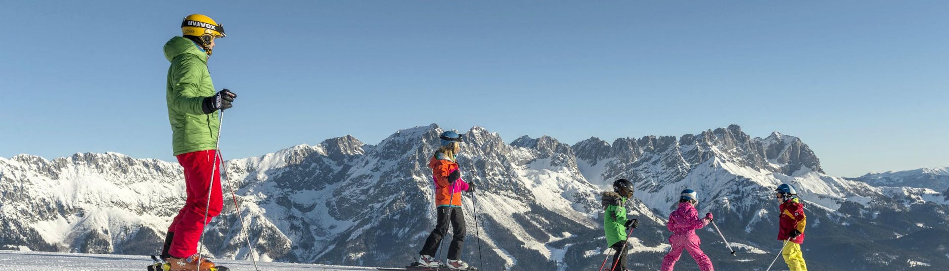 Eine Familie verbringt einen gemeinsamen Tag auf den Skipisten von Going-Ellmau, wo örtliche Skischulen ihre Skikurse für all jene die das Skifahren lernen wollen durchführen.