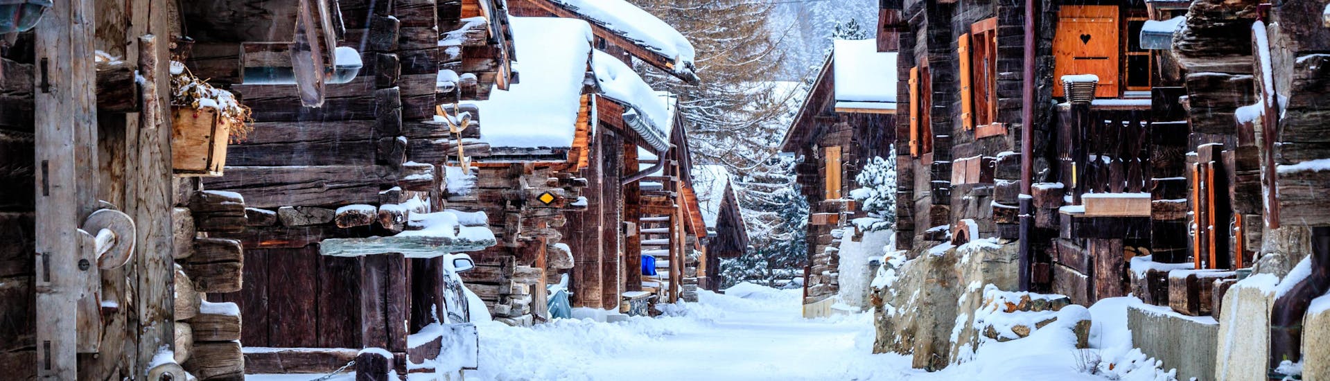 An image of the wooden chalets in the small Swiss ski resort of Grimnetz-Zinal, a popular destination for skiers who want to book ski lessons with one of the local ski schools.