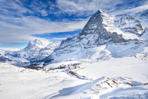 Blick auf die verschneiten Pisten von Grindelwald in der Jungfrauregion, wo viele Skischulen ihre Skikurse anbieten.