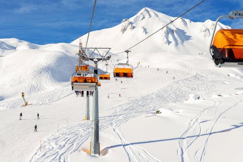 A ski lift and the snowy slopes of Silvretta Arena Ischgl, where a local ski school offers their ski lessons.