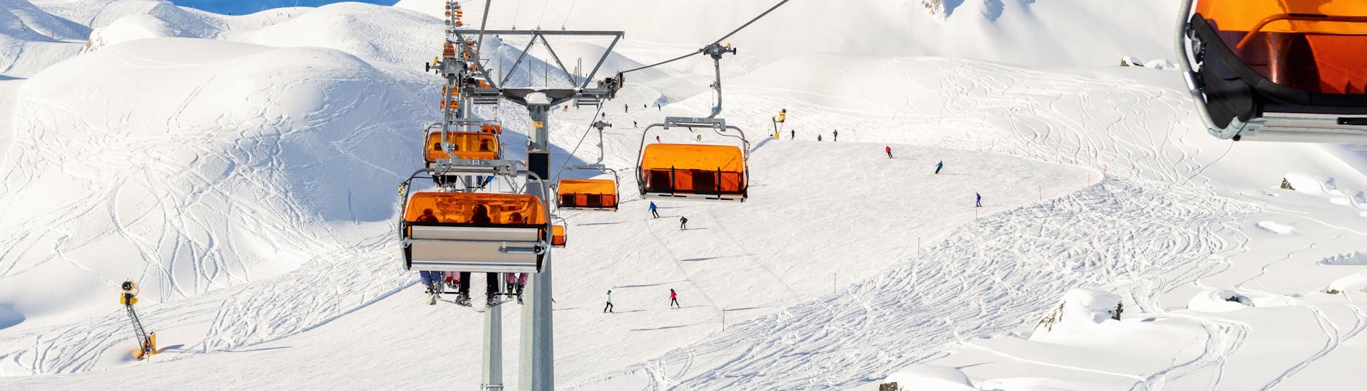 Ein Skilift und die verschneiten Pisten der Silvretta Arena Ischgl, wo eine örtliche Skischule ihre Skikurse anbietet.