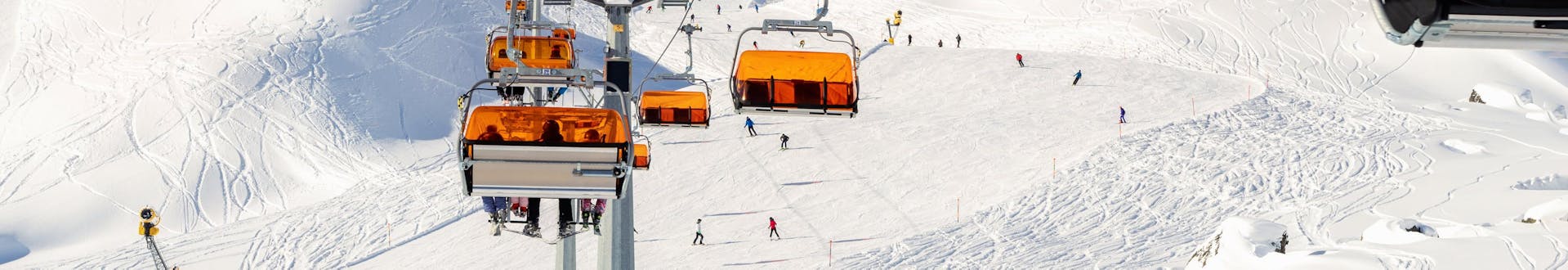 Ein Skilift und die verschneiten Pisten der Silvretta Arena Ischgl, wo eine örtliche Skischule ihre Skikurse anbietet.