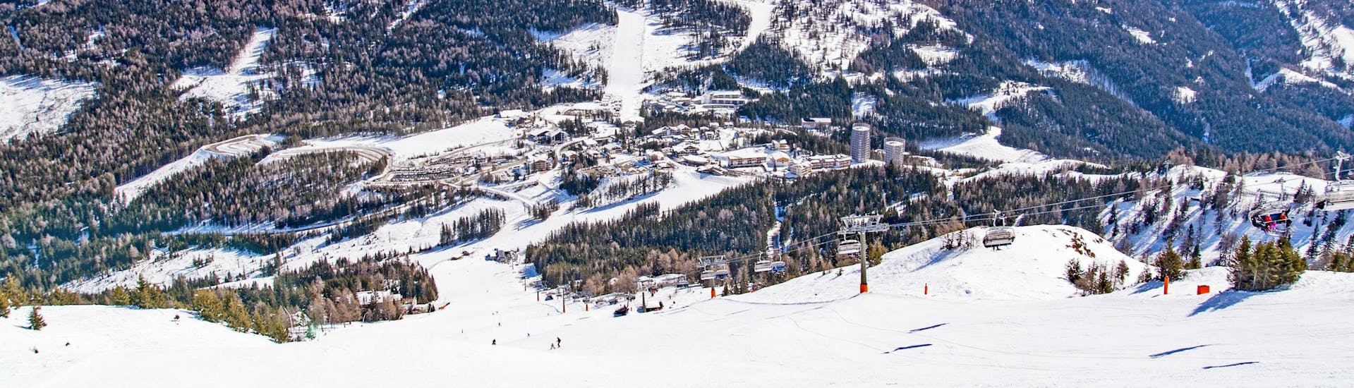 Ein Blick auf die schneebedeckten Pisten am Katschberg in Kärnten, wo Skifahrer mit einer der örtlichen Skischulen einen Skikurs buchen können.