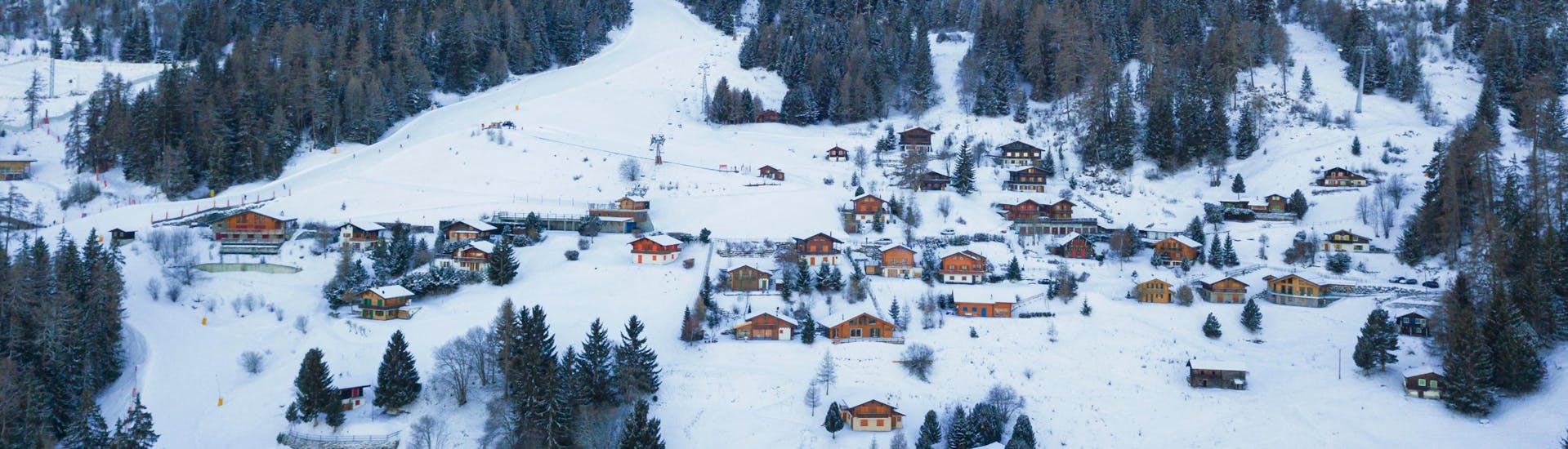 Eine Luftaufnahme der Skipisten von La Tzoumaz, einem beliebten schweizer Skigebiet in dem Besucher bei einer der örtlichen Skischulen einen Skikurs buchen können.