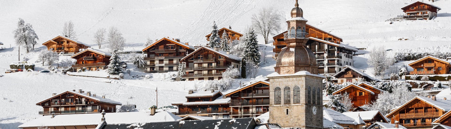 View of the town of the French ski resort of Le Grand Bornand with its church and wooden chalets where local ski schools offer a wide range of ski lessons for those who want to learn to ski.