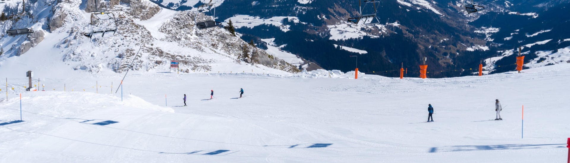 An image of several skiers riding down one of the ski slopes in the Swiss ski resort of Leysin, a popular destination for aspiring skiers who wish to learn to ski by taking ski lessons with one of the local ski schools.