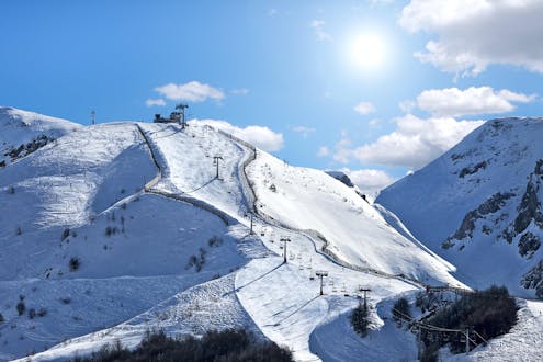 Blick auf die sonnigen Pisten des Skigebiets in Limone Piemonte, wo örtliche Skischulen ihre Skikurse anbieten.