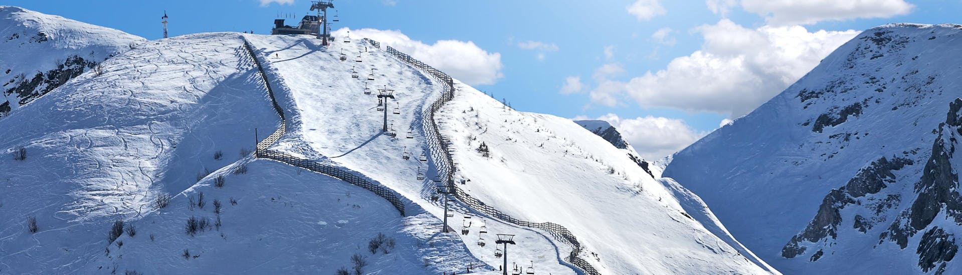 Blick auf die sonnigen Pisten des Skigebiets in Limone Piemonte, wo örtliche Skischulen ihre Skikurse anbieten.