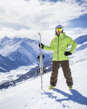 Ein Skifahrer posiert auf einer Skipiste in Livigno mit Blick vom Berg hinunter auf das schneebedeckte Tal.