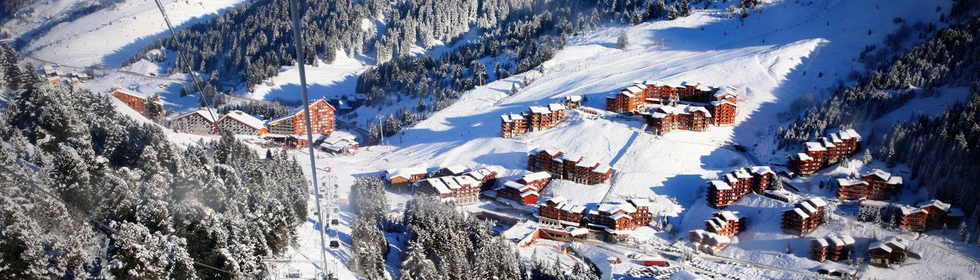 A view of the ski resort of Méribel with gondolas ascending one of the mountains where the local ski schools offer a variety of ski lessons. 