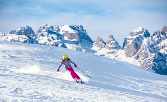 Una ragazza sta sciando nella splendida stazione sciistica del Monte Bondone, dove le scuole di sci locali offrono le loro lezioni di sci.