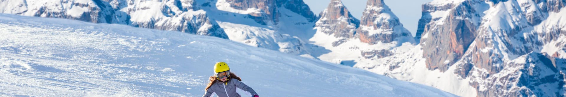 Una ragazza sta sciando nella splendida stazione sciistica del Monte Bondone, dove le scuole di sci locali offrono le loro lezioni di sci.