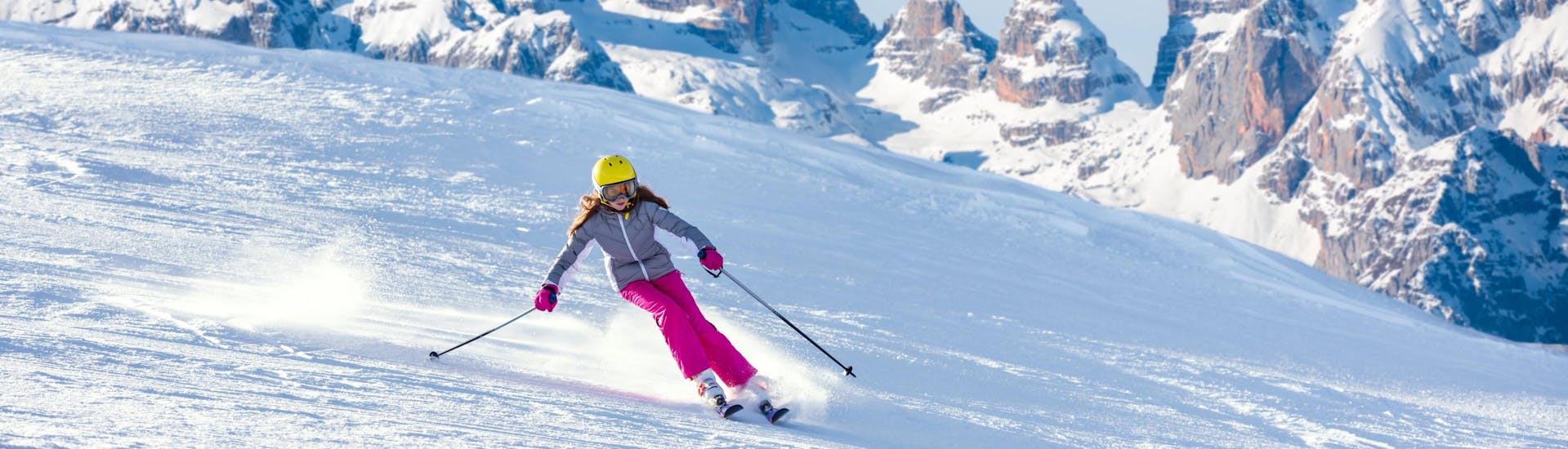 A girl is skiing in the stunning ski resort of Monte Bondone, where local ski schools offer their ski lessons.