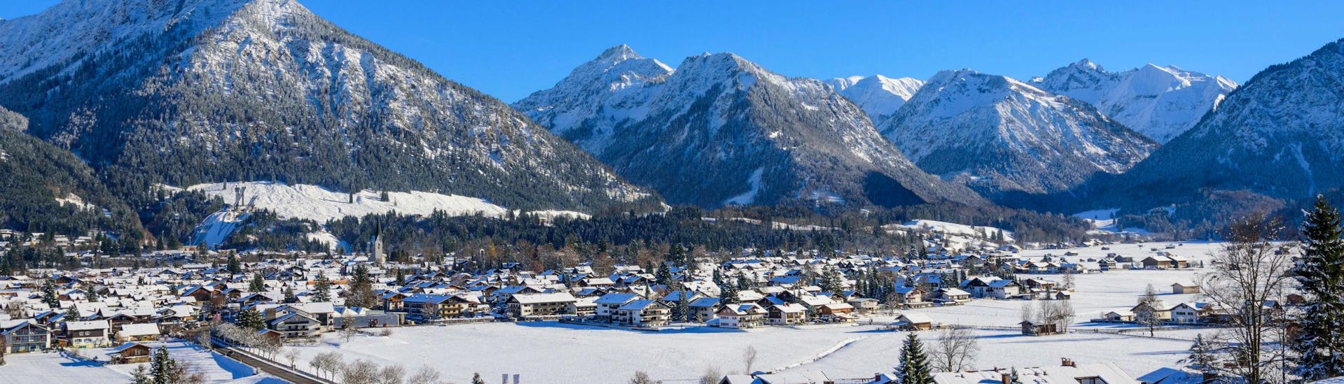 Blick auf die malerische Ortschaft Oberstorf, ein von den bayrischen Alpen umzingeltes Skigebiet in dem die örtlichen Skischulen eine Vielzahl an Skikursen anbieten. 