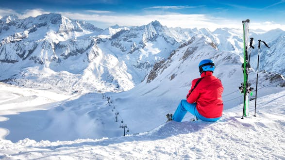 Ein Skifahrer macht eine kurze Pause von seinem Skikurs mit einer der örtlichen Skischulen aus Ponte di Legno und genießt das umliegende Bergpanorama.