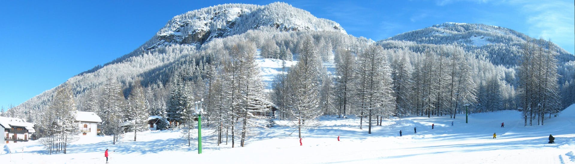 Una maravillosa vista de un soleado paisaje en la cima de la estación de esquí Pragelato, punto de encuentro de las escuelas de esquí para comenzar sus clases de esquí y snowboard.