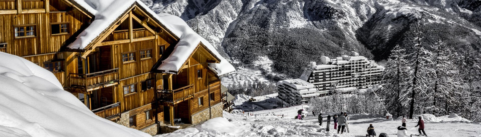 Une vue de la station de ski française de Puy Saint Vincent 1800 avec ses chalets en bois et ses pistes où les écoles de ski locales offrent un large éventail de cours de ski pour ceux qui veulent apprendre à skier.
