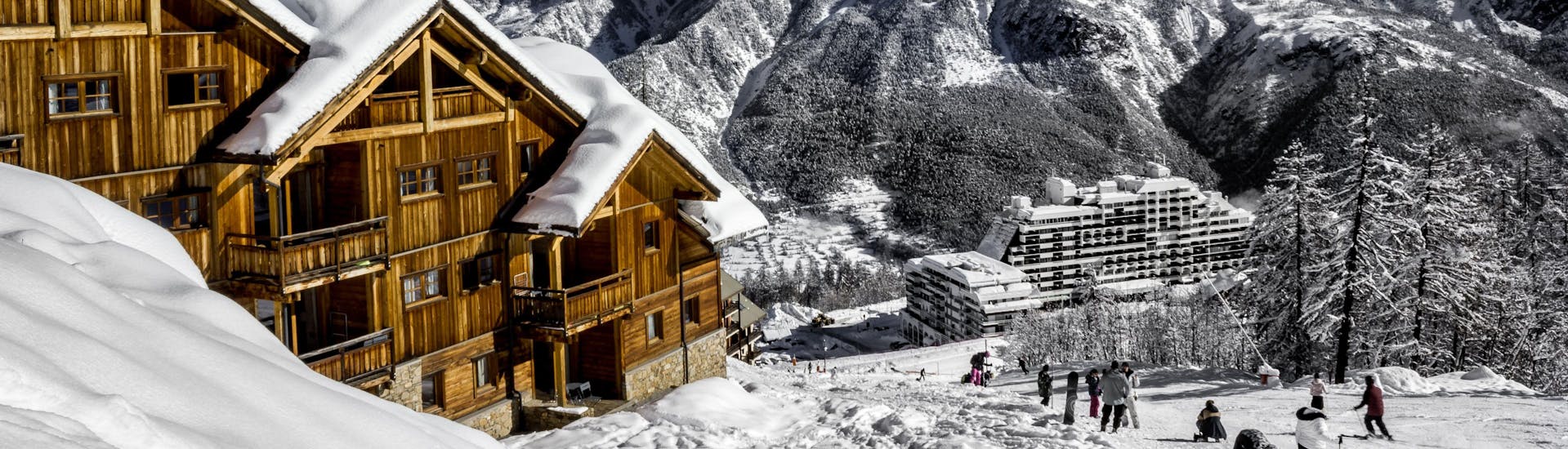 Une vue de la station de ski française de Puy Saint Vincent 1400 avec ses chalets en bois et ses pistes où les écoles de ski locales offrent un large éventail de cours de ski pour ceux qui veulent apprendre à skier.