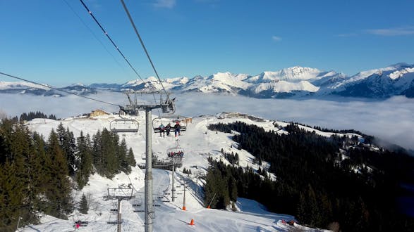 Un télésiège à Samoëns transporte un groupe de skieurs et leur moniteur de ski d'une des écoles de ski locales jusqu'au sommet de la montagne où ils commenceront leurs cours de ski.