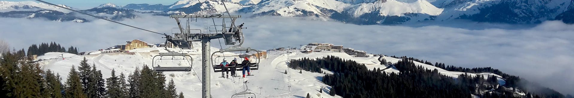 Un télésiège à Samoëns transporte un groupe de skieurs et leur moniteur de ski d'une des écoles de ski locales jusqu'au sommet de la montagne où ils commenceront leurs cours de ski.
