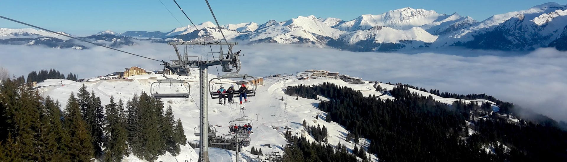 A chair lift in Samoens is carrying a group of skiers and their ski instructor from one of the local ski schools up to the top of the mountain where they will get started with their ski lessons.