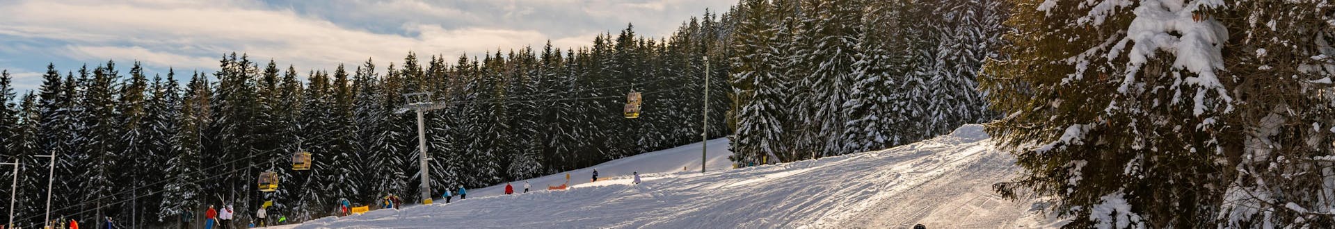 Blick auf die Pisten und einen Sessellift im Skigebiet Schladming - Planai, wo die örtlichen Skischulen ihre Skikurse anbieten.