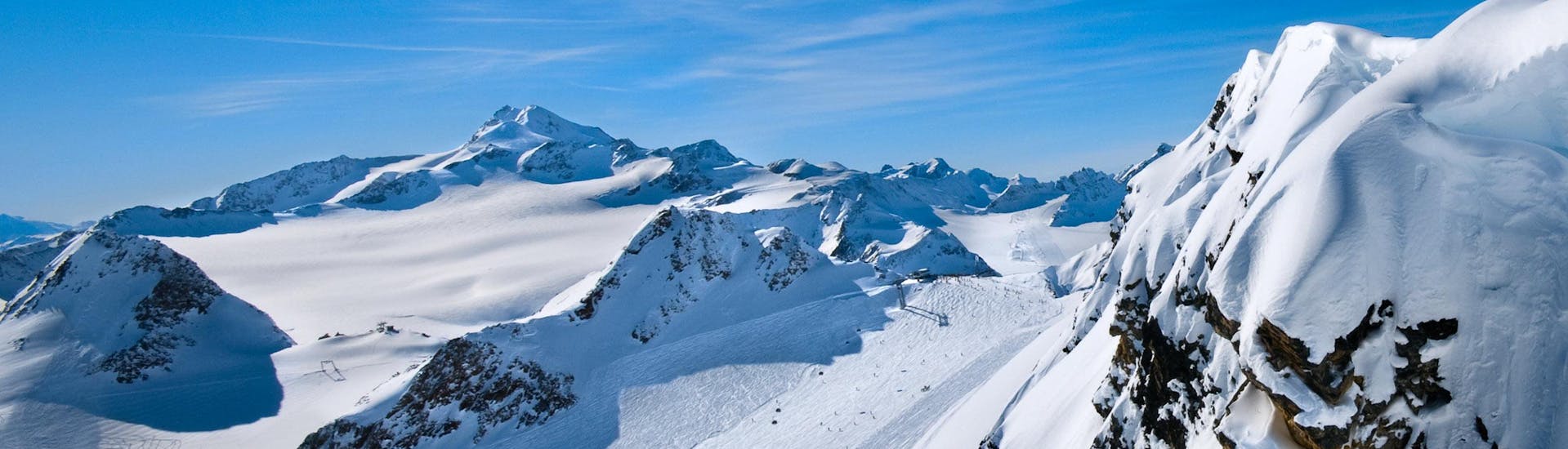 A view of a snowy mountain top in the ski resort of Plagne Aime 2000, where ski schools gather to start their ski lessons.