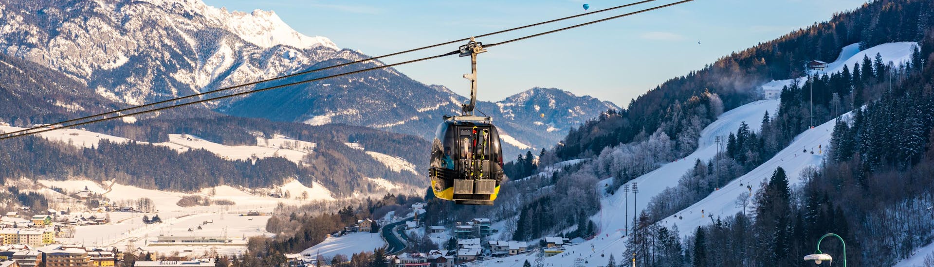 A cable car is suspended over the town of Schladming, a popular destination for ski schools that offer ski lessons in the Ski Amadé Schladming Dachstein region.